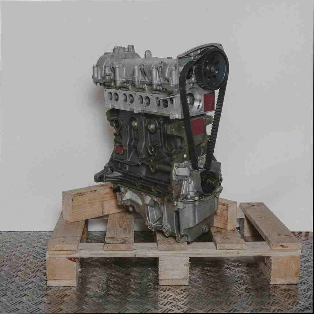 Kompletter Motor 198 A2.000 auf Holzpalette vor weißem Hintergrund. Seitenansicht des Metallmotors, leicht geneigt.