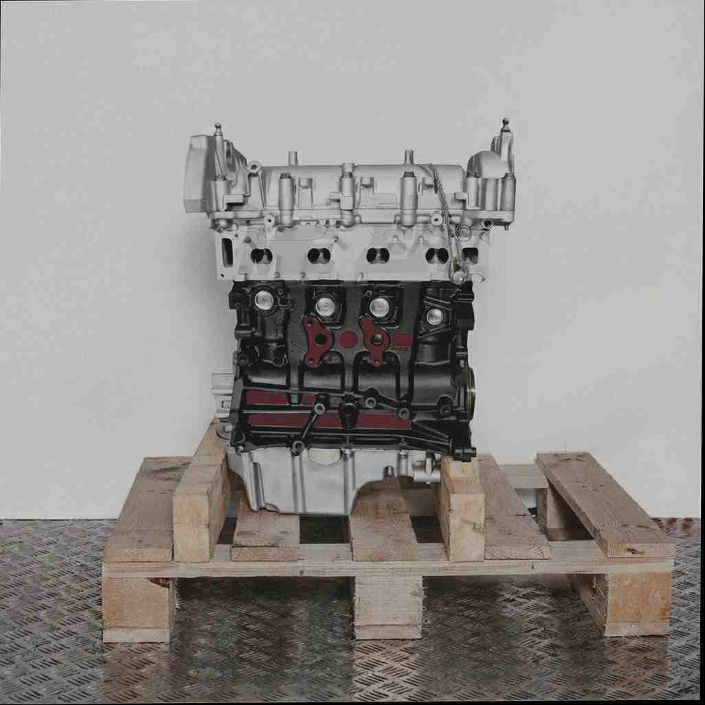 Motor 263 A3.000 auf Holzpalette vor weißem Hintergrund. Seitenansicht des Motors, silberfarbener oberer Teil und schwarzer Block.