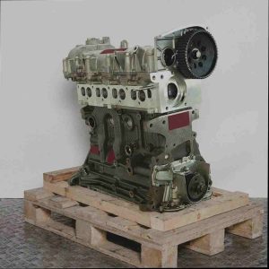 Motor 955 A3.000 auf Holzpalette vor weißem Hintergrund. Seitenansicht des Metallmotors, leicht schräg von oben aufgenommen.