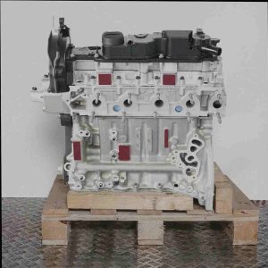 Seitenansicht eines grauen Motors mit schwarzer Abdeckung, Motorcode 9HT (DV6BTED4), auf einer Holzpalette vor weißem Hintergrund. Der Motor ist vertikal ausgerichtet.