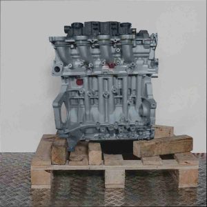 Kompletter Motor 9HV (DV6TED4B) auf Holzpalette vor weißem Hintergrund. Der Motor besteht hauptsächlich aus silbernen Metallteilen.