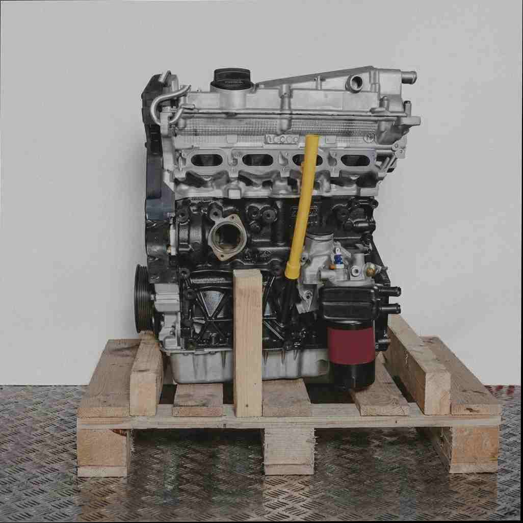 Motor AWC auf Holzpalette vor weißem Hintergrund. Der schwarze und silberne Motor mit gelbem Ölmessstab ist vertikal ausgerichtet.