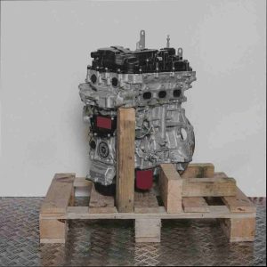 Seitenansicht eines Motors B 12 XHT (EB2DTS) auf einer Holzpalette vor weißem Hintergrund. Der hellgraue und schwarze Motor ist vertikal ausgerichtet.