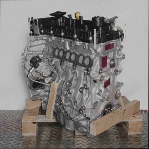 Motor B 16 DTU auf Holzpalette vor weißem Hintergrund. Seitenansicht des Motors, leicht schräg von vorne.