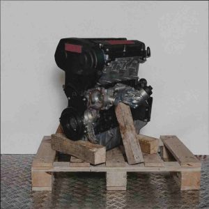 Schwarzer und silberner Motor B 16 XER auf Holzpalette vor weißem Hintergrund. Der Motor ist leicht schräg von der Seite zu sehen.