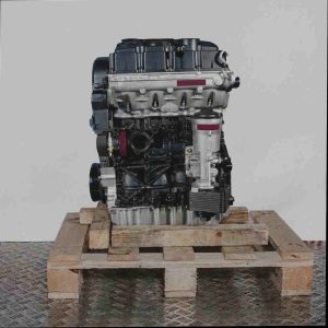 Schwarzer und silberner BMM Motor auf Holzpalette vor weißem Hintergrund. Der Motor ist vertikal ausgerichtet.