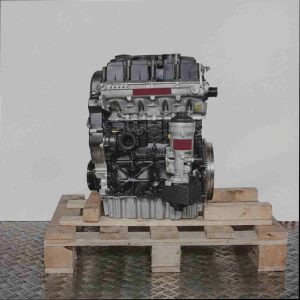 Schwarz-silberner Motor BMP auf Holzpalette vor weißem Hintergrund. Seitenansicht des Motors, der vertikal ausgerichtet ist.