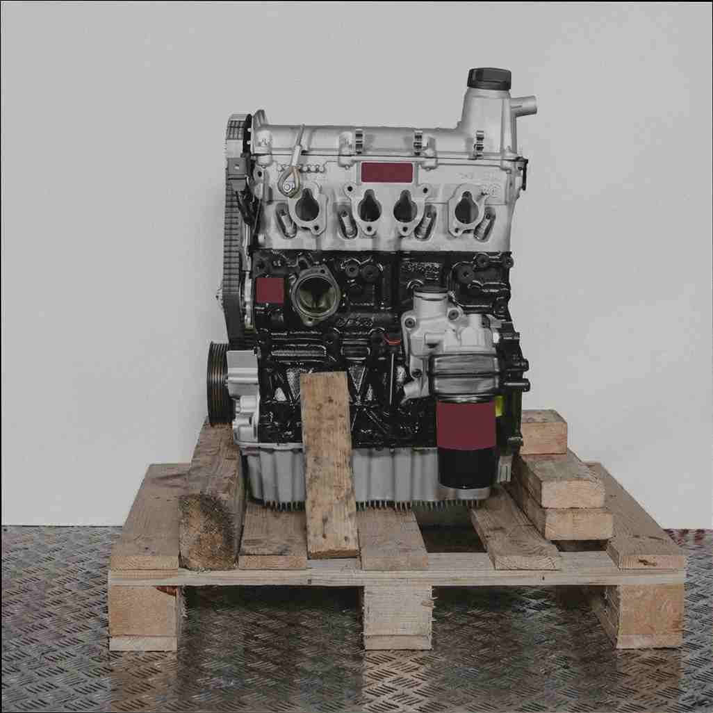 Motor BSX auf Holzpalette vor weißem Hintergrund. Der schwarze Motorblock und silberne Zylinderkopf sind deutlich zu sehen. Ölfilter angebracht.