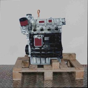 Seitenansicht eines CAVD Motors auf einer Holzpalette vor weißem Hintergrund. Der silberne obere und schwarze untere Teil des Motors sind deutlich zu erkennen, inklusive Ölfilter.