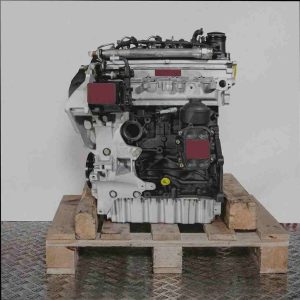 Seitenansicht eines CAYB Motors auf einer Holzpalette vor weißem Hintergrund. Der silber-schwarze Motor zeigt Details wie Einspritzdüsen und Leitungen.