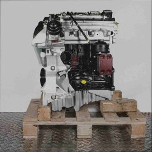 Seitenansicht des Motors CSUE auf einer Holzpalette vor weißem Hintergrund. Der silber-schwarze Motor mit gelben Akzenten ist vertikal ausgerichtet.
