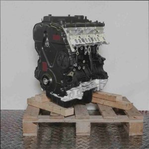 Schwarzer und silberner Motor ENQW auf Holzpalette vor weißem Hintergrund. Verschiedene Motorbauteile wie Zylinderkopf und Ölwanne sind sichtbar. Der Motor steht leicht schräg.