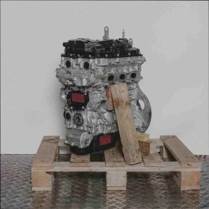 Frontalansicht eines Motors vom Typ F 12 XHT (EB2ADTS) auf einer Holzpalette vor weißem Hintergrund. Der silberne Motor mit schwarzen Komponenten ist vollständig sichtbar.