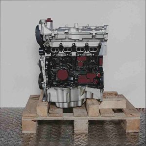 K4M 706 Motor auf Holzpalette vor weißem Hintergrund. Der silber-schwarze Motor mit gelben und grünen Akzenten ist seitlich abgebildet.