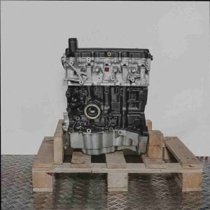 Motor K9K 718 auf Holzpalette vor weißem Hintergrund. Das Bild zeigt einen schwarzen und silbernen Motor in Seitenansicht.