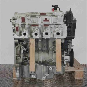 Grau-schwarzer Motor K9K 872 auf Holzpalette vor weißem Hintergrund. Detailaufnahme des Motorblocks und der Anbauteile, seitliche Perspektive.