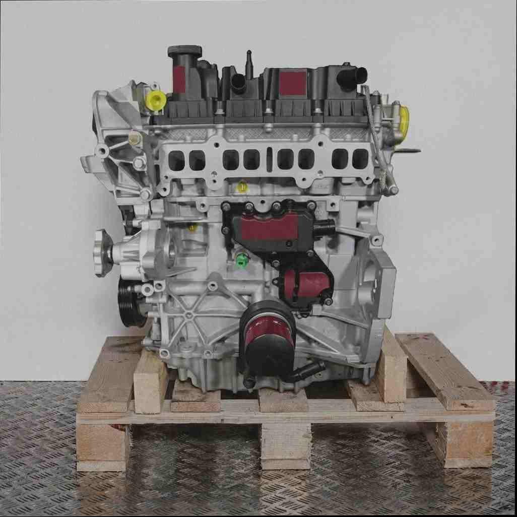 Verbrennungsmotor M9MB auf Holzpalette vor weißem Hintergrund. Der Motor aus Aluminium und Kunststoff ist vollständig sichtbar.