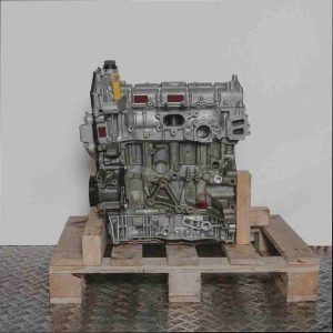 Seitenansicht des Motors YN2X auf einer Holzpalette vor weißem Hintergrund. Der Motor, in Grautönen gehalten, zeigt die Vorderseite mit gelber Ölmessstab-Lasche.
